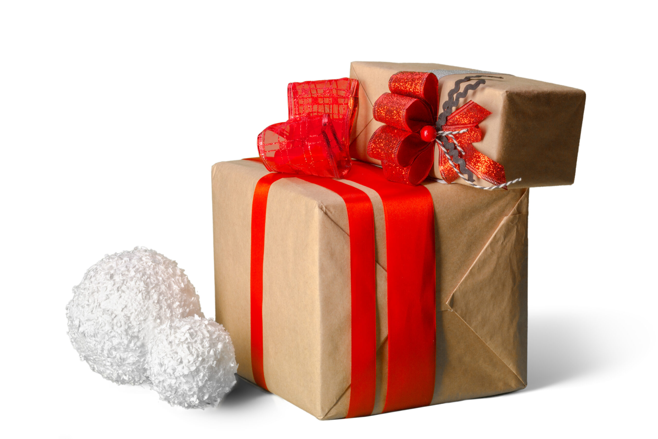 Two gift boxes wrapped in brown kraft paper with red ribbons and bows on a white backdrop.